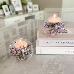 two candles are sitting on top of some books