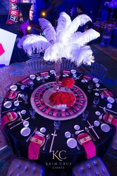 a casino table decorated with white feathers and red roses