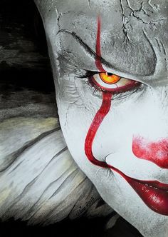 a close up of a clown's face with red eyes