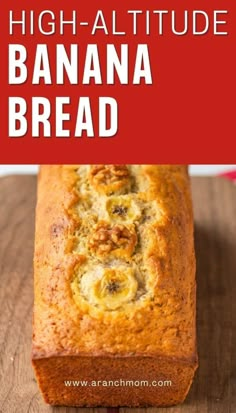 a loaf of banana bread sitting on top of a wooden table next to a red sign that says high altitude banana bread