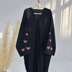 This open abaya is trending now and we know why! An stylish open abaya embroidered with butterflies on the sleeves, a low shoulder shrug stitching, stunning colors, breathable nida fabric, and button closures to take this from an open abaya to a closed abaya! Style up or down for an effortlessly classy look. Available in 4 colors and 5 sizes. Closed Abaya Designs, Shrug Stitching, Trending Abaya Designs, Unique Abaya Designs, Luxurious Abaya, Arabic Abaya, Burkha Designs, Closed Abaya, Shoulder Shrug