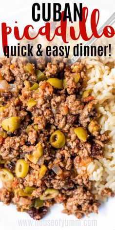 a white plate topped with rice covered in meat and olives next to a fork