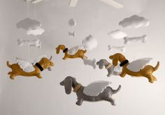 a mobile with dogs hanging from it's sides and clouds in the sky above