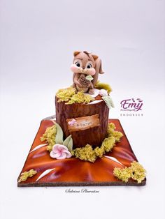 a cake made to look like a tree stump with a squirrel on it's head