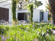 the house is surrounded by greenery and flowers