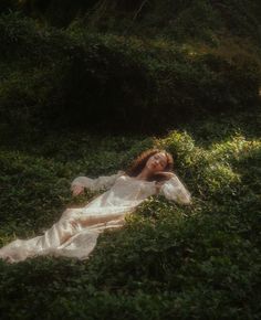 a woman laying in the grass with her head down