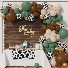 a baby shower is decorated with balloons and cow print