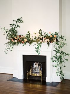 a fireplace decorated with greenery and candles