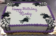 a birthday cake decorated with spider webs and purple icing