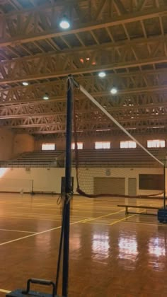 an indoor volleyball court with lights on the ceiling and net in the middle of it