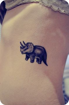 a rhino tattoo on the side of a woman's stomach