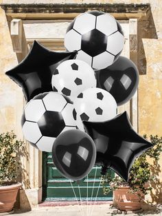 a bunch of black and white balloons in the shape of soccer balls