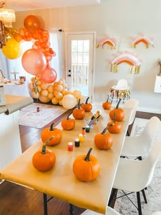 a table with pumpkins and balloons on it