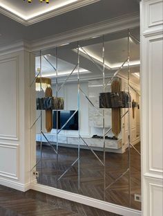 a mirrored wall in the middle of a room with mirrors on it's sides