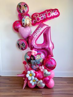 the balloon centerpiece is made up of pink balloons and heliums with barbie's birthday pictures on them