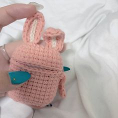 a hand holding a pink knitted bunny toy