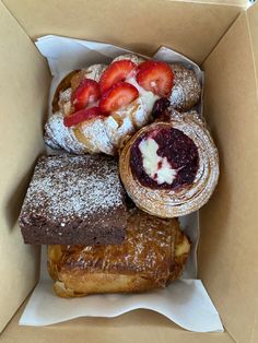 a box filled with pastries and strawberries on top of eachother,