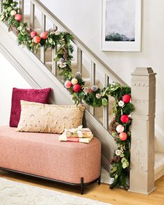 the stairs are decorated with christmas garland and poinsettis for an elegant look