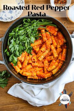 roasted red pepper pasta in a skillet with parsley and herbs on the side