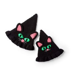 two black crocheted cat mittens with green eyes and pink ears on white background