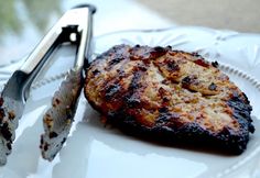 a grilled meat on a plate with a knife and fork