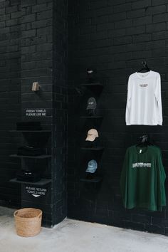 several hats and t - shirts are hanging on the wall