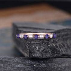 a close up of a ring on top of a rock with blue and white stones