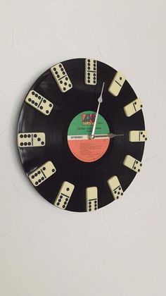 a black clock with white dominos on it