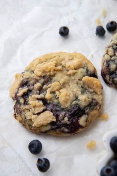 two blueberry crumb cookies sitting on top of white paper