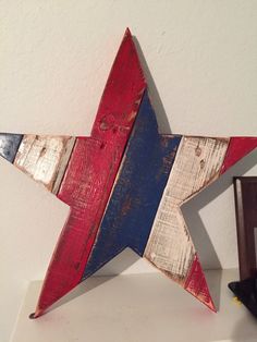 a red, white and blue wooden star on a shelf