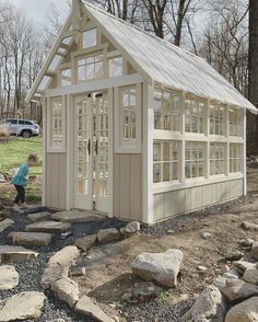 a little boy standing in front of a small building