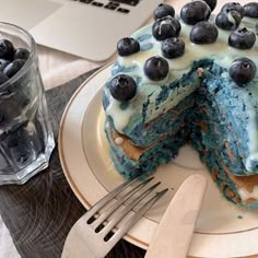 a cake with blueberries and cream frosting on a plate