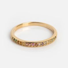 a yellow gold band with different colored stones