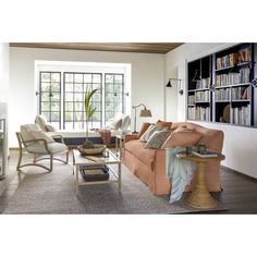 a living room filled with furniture and bookshelves in front of a large window