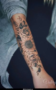 a woman with a sunflower tattoo on her arm and wrist is sitting in a chair