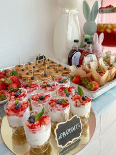 an assortment of desserts and pastries displayed on a buffet table with bunny ears