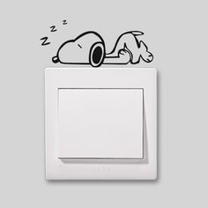 a light switch with a sticker of a dog sleeping on it's side