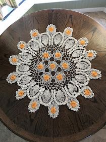 an orange and white doily sitting on top of a wooden table