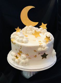 a white cake with gold stars and a crescent on top is sitting on a plate