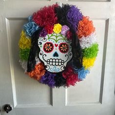 a colorful sugar skull wreath hangs on the front door to greet someone with special care