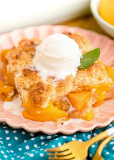 a peach cobbler on a pink plate with a scoop of ice cream in the middle