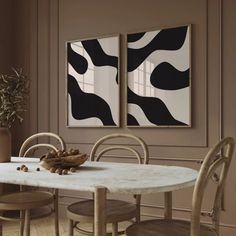 a dining room with two paintings on the wall