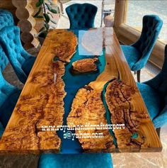 the table is made out of wood and has blue chairs around it, along with a large wooden slab