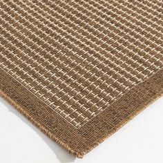 a close up view of a brown rug on a white surface with no one in it