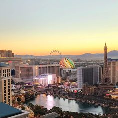 the las vegas strip at sunset with hot air balloons in the sky and ferris wheel