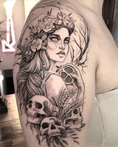 a woman with flowers and skulls tattoo on her arm is shown in black and white