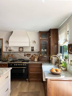 a kitchen with wooden cabinets and marble counter tops