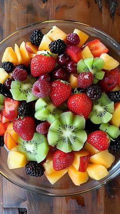 a glass bowl filled with fruit on top of a wooden table