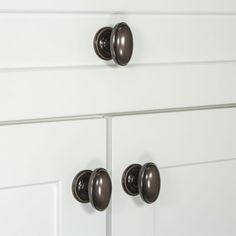 two white drawers with black knobs and handles