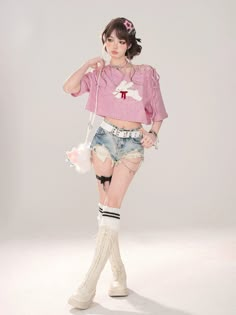 a woman in short shorts and a pink shirt is posing for the camera with her hand on her hip